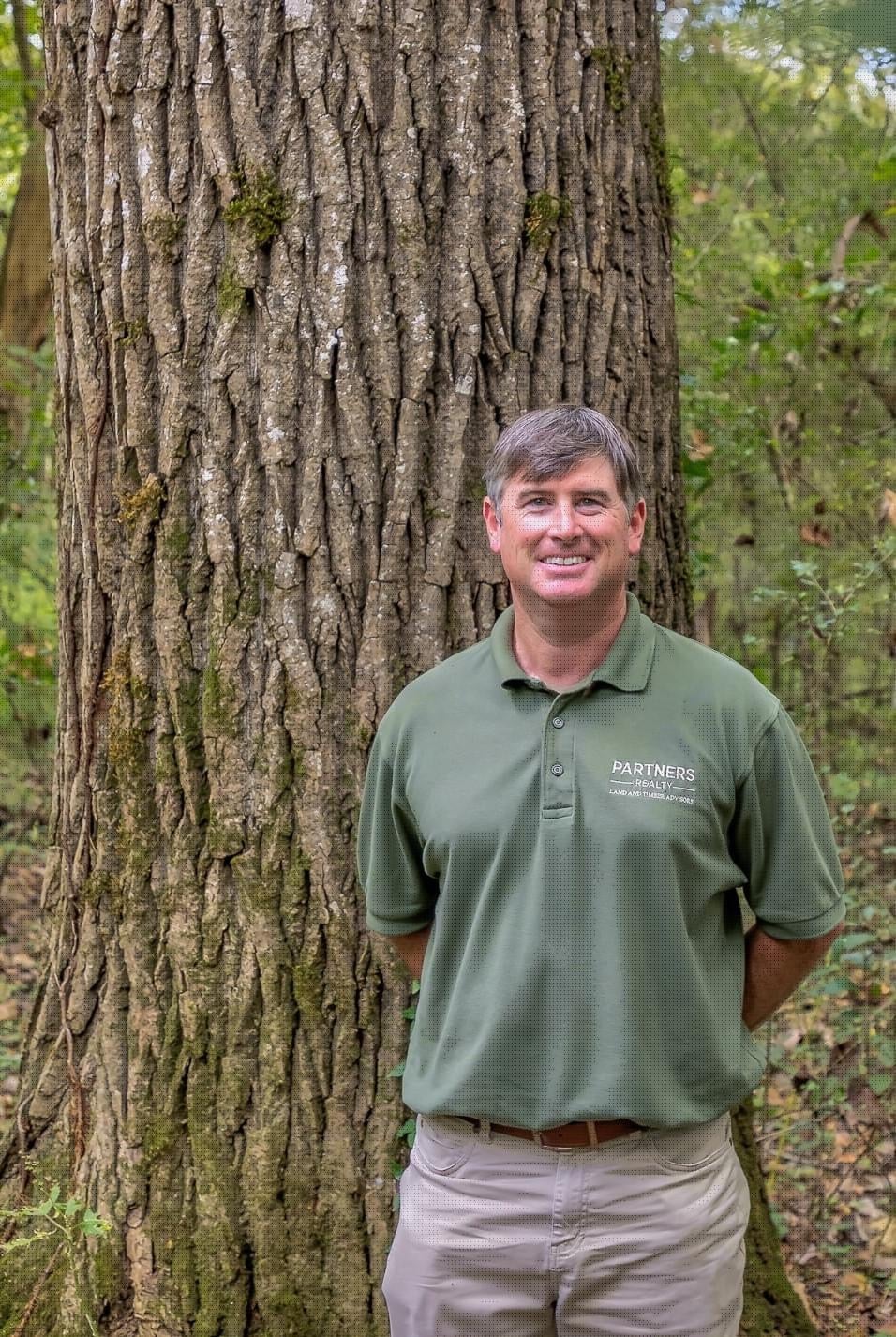 a man standing in front of a tree
